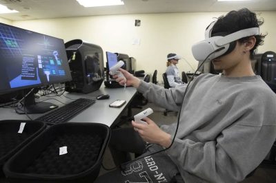 student uses virtual reality headset and hand controls